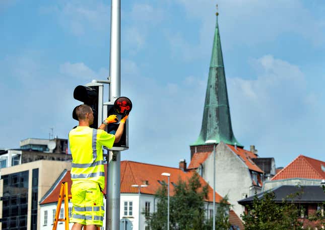 A technician replaces one of many pedestrian signals featuring Vikings in Aarhus, Denmark on Aug 26.
