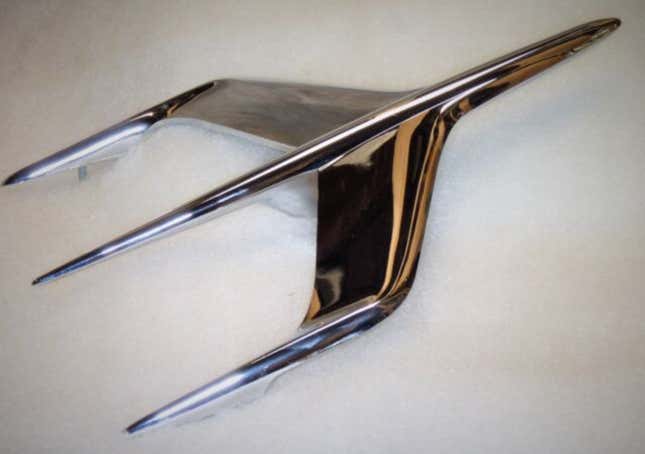 The jet age styled plane hood ornament from a 1955 Mercury Montclair on a white background