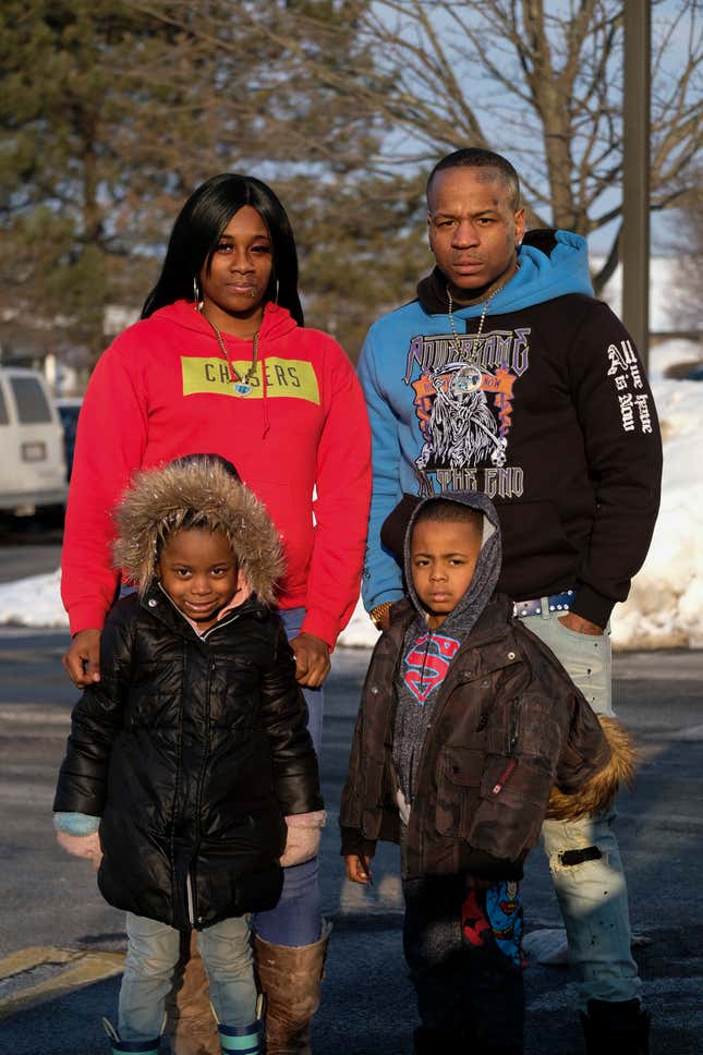 Johnathan King, 31, poses with his girlfriend Brianna Hernandez, their daughter, Zariyah King, 5, and their son Johnathan King, 4, in front of Extended Stay America, an economy apartment hotel chain, where he stayed with his girlfriend and their three children last winter in Schaumburg, IL. The couple was forced out of their subsidized housing apartment at Buena Vista Townhouse Complex in Elgin, IL.