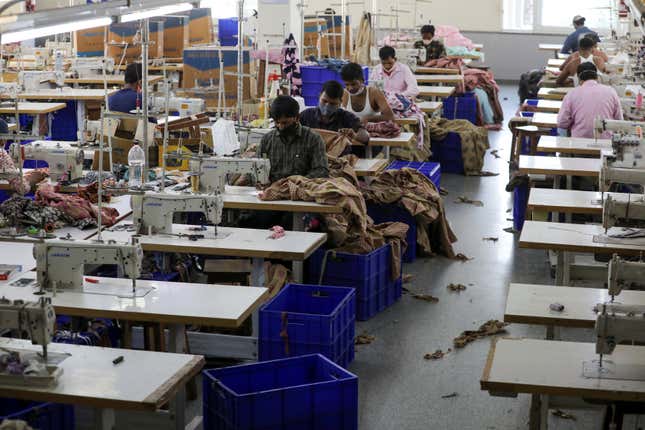 Workers stitch garments at a factory of an apparel shop in Jaipur, India