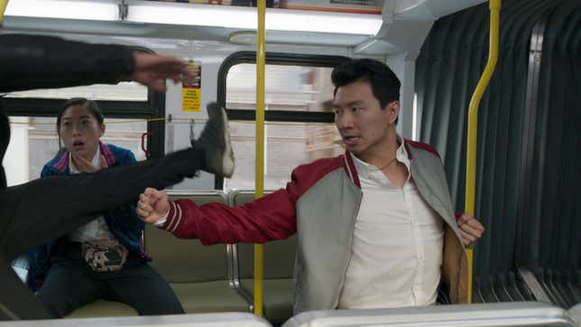 Simu Liu's Shang-Chi punches a thug flying as his friend Katy (Awkwafina) watches.