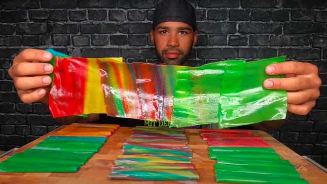 Man holding up row of multicolored Fruit Roll Ups