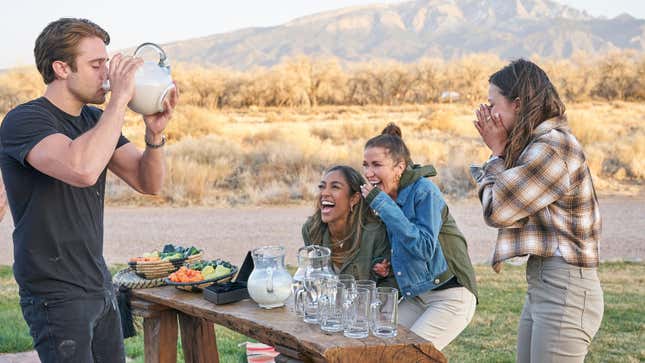 Greg drinks a pitcher of milk next to a platter of hot peppers while Tayshia Adams, Kaitlyn Bristowe, and Katie Thurston laugh in The Bachelorette