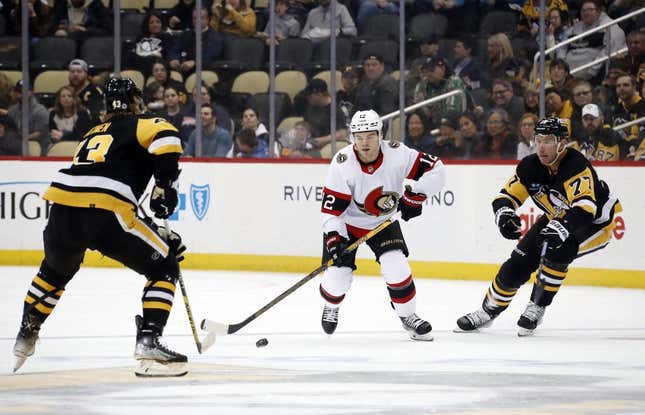 Mar 20, 2023; Pittsburgh, Pennsylvania, USA; Ottawa Senators right wing Alex DeBrincat (12) skates up ice with the puck against Pittsburgh Penguins defenseman Pierre-Olivier Joseph (73) and center Jeff Carter (77) during the second period at PPG Paints Arena.