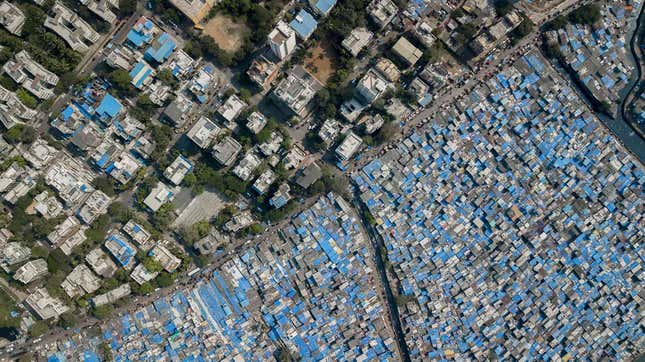 The contrast between Dharavi’s tarpaulin covered shanties and the permanent structures beyond.