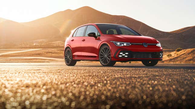 A red 40th Anniversary Edition GTI is parked on pavement near sunset.