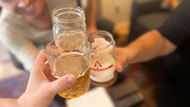 Beer held up in a toast in various glasses
