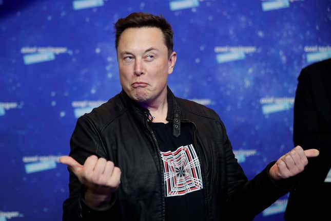 Elon Musk gestures with both thumbs.