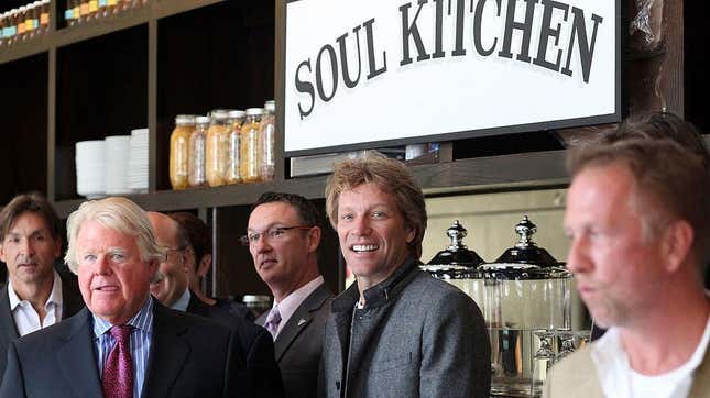 Jon Bon Jovi in front of "Soul Kitchen" restaurant sign