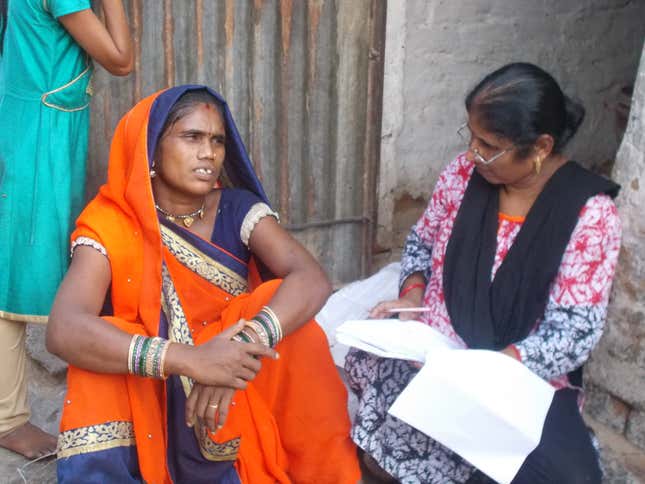 A Mobile Creche childcare worker speaks with a woman in Sector 68