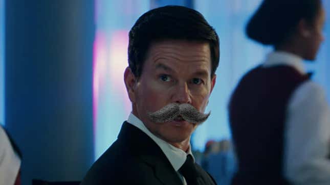 Mark Wahlberg wears a bad tux and a bushy fake mustache while standing in a bar in the Uncharted movie.