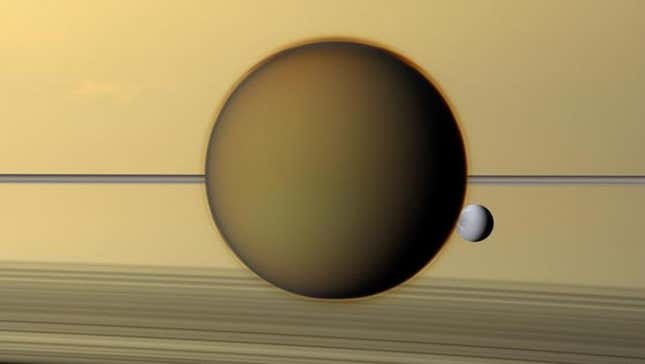 The large moon Titan, with Saturn and its rings in the background.