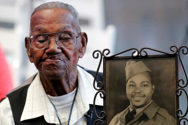 World War II veteran Lawrence Brooks holds a photo of him taken in 1943, as he celebrates his 110th birthday at the National World War II Museum in New Orleans, on Sept. 12, 2019. Brooks, the oldest World War II veteran in the U.S. — and believed to be the oldest man in the country — died on Wednesday, Jan. 5, ,2022 at the age of 112. 