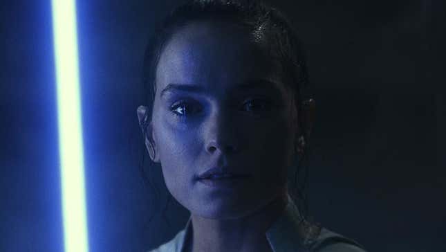 Rey holds a light saber in The Force Awakens. 