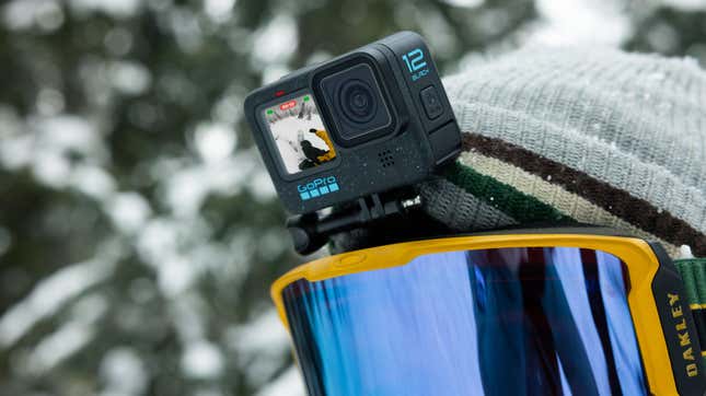 A GoPro Hero12 Black attached to a head mount on a snowboarder with yellow goggles.