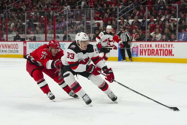 Dec 20, 2022; Raleigh, North Carolina, USA; New Jersey Devils defenseman Ryan Graves (33) controls the puck against Carolina Hurricanes right wing Jesper Fast (71) during the first period at PNC Arena.