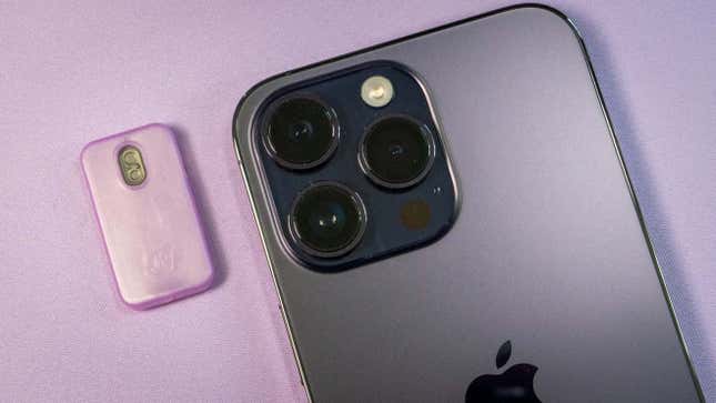 Detalle de las cámaras del iPhone 14 Pro junto a un pequeño dispositivo.