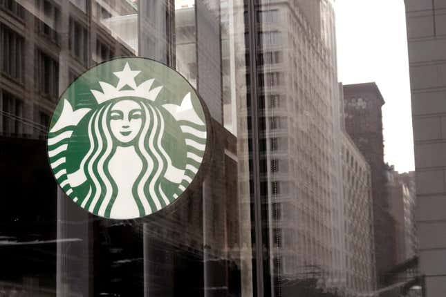 A Starbucks logo hangs in the window of one of the chain's coffee shops.