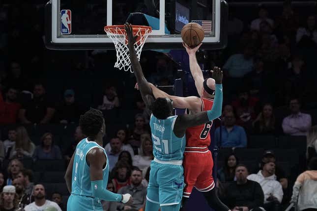 Mar 31, 2023; Charlotte, North Carolina, USA; Chicago Bulls guard Alex Caruso (6) shoots the ball over Charlotte Hornets forward JT Thor (21) in the first quarter at Spectrum Center.