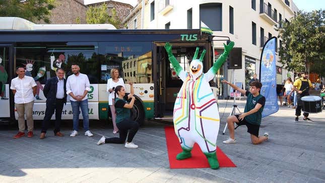 La Bussi stands in a triumphant pose in front of a bus in the city of Sabadell.