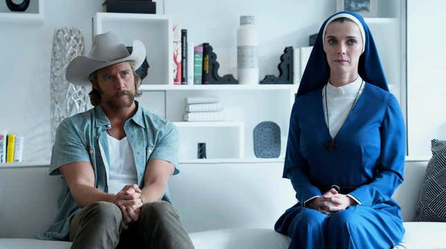 A man in a cowboy hat and a nun sit on a white couch