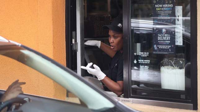 an employee at a Taco Bell drive-thru talks to a customer