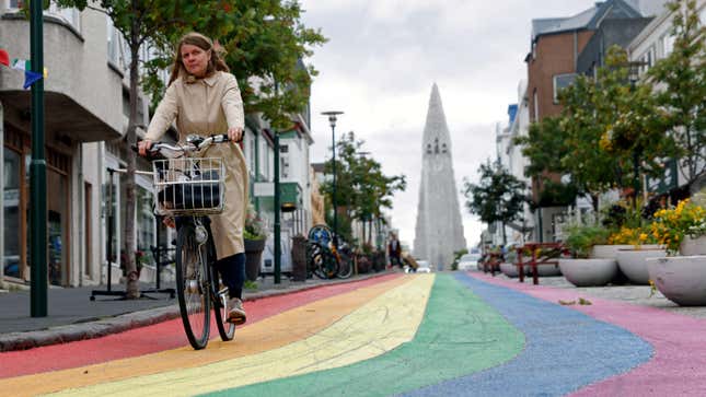 A woman cycles down a street painted in rainbow colours near the Hallgrimskirkja church, as the outbreak of the coronavirus disease (COVID-19) continues, in Reykjavik, Iceland