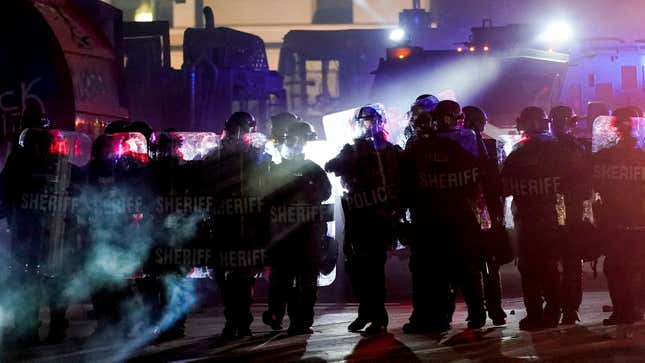 Riot police clearing a square in Kenosha, Wisconsin, where an armed group calling itself the Kenosha Guard organized on Facebook to confront Black Lives Matter protesters before a vigilante killed two and wounded another. The Kenosha Guard is now on Facebook's Dangerous Individuals and Organizations list.