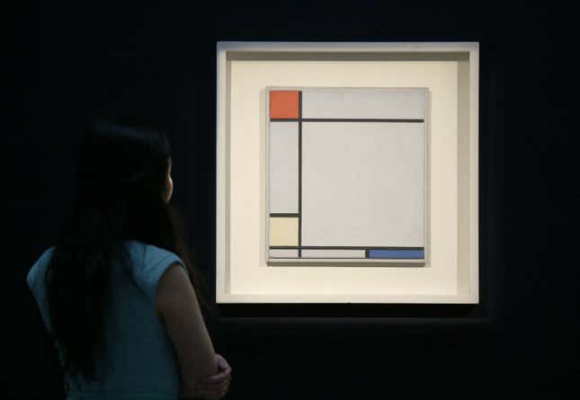 A Sotheby’s employee poses with Mondrian’s 1927 painting ‘Composition with Red, Yellow and Blue’ on display at the auction house in in 2013.