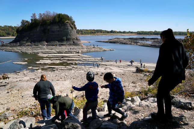 People walk toward Tower Rock to check out the attraction normally surrounded by the Mississippi River and only accessible by boat, Oct. 19, 2022, in Perry County, Mo. 