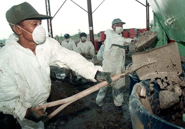 Cambodian soldiers handle toxic waste from Formosa Plastics near Sihanoukville in March 1999.