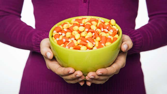 Hands holding bowl of candy corn