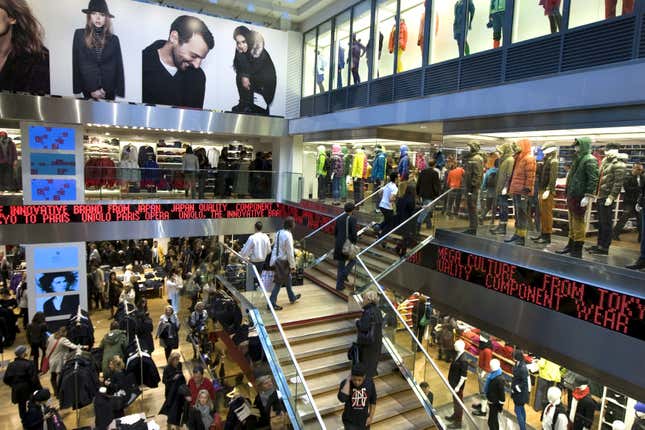 Customers shop inside the casual clothing store Uniqlo operated by Japan's Fast Retailing in Paris in this October 6, 2009 file photo. REUTERS/Charles Platiau/File Photo GLOBAL BUSINESS WEEK AHEAD PACKAGE - SEARCH 'BUSINESS WEEK AHEAD 24 OCT' FOR ALL IMAGES - S1AEUITDFHAA