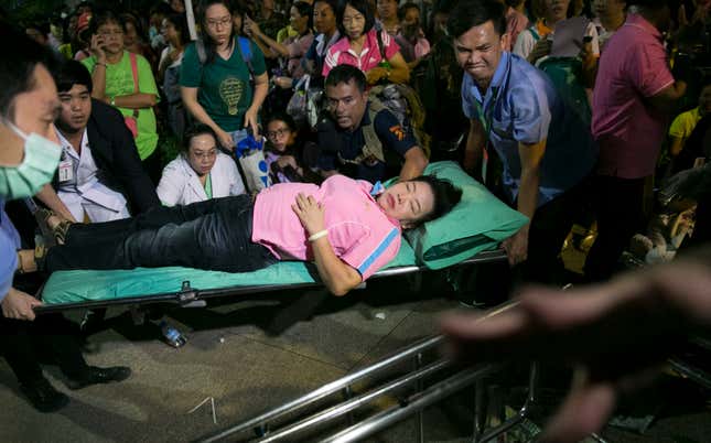 A Thai woman is overcome with emotion and is assisted at Siriraj Hospital where Thai King Bhumibol Adulyadej was being treated in Bangkok, Thailand, Oct. 13. (AP Photo/Wason Wanichakorn)