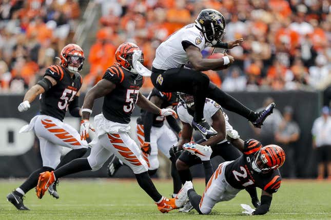 Sep 17, 2023; Cincinnati, Ohio, USA; Baltimore Ravens quarterback Lamar Jackson (8) jumps over Cincinnati Bengals cornerback Mike Hilton (21) during the first half at Paycor Stadium.