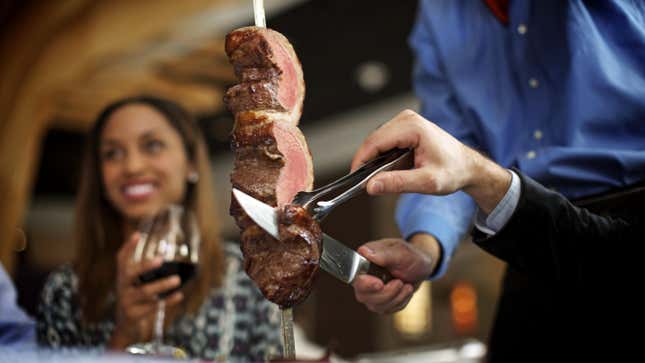 Churrascaria meat served from spear at restaurant