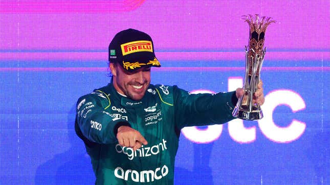 A photo of Fernando Alonso holding his F1 trophy. 