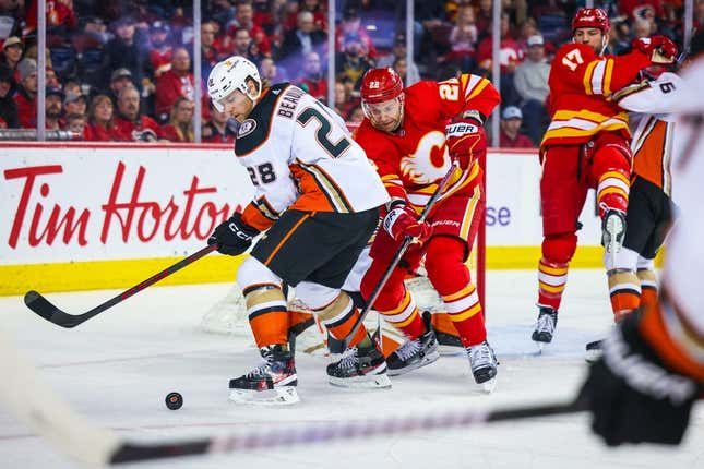Apr 2, 2023; Calgary, Alberta, CAN; Anaheim Ducks defenseman Nathan Beaulieu (28) and Calgary Flames center Trevor Lewis (22) battle for the puck during the second period at Scotiabank Saddledome.