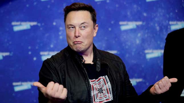 Elon Musk grimaces and gestures with two thumbs