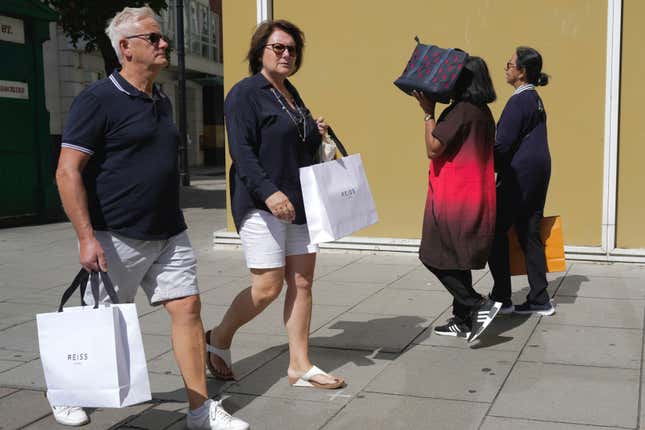 People walk along a street in a shopping district in central London, Tuesday, Aug. 22, 2023. Analysis of the Bank of England&#39;s latest Monetary Policy shows, the UK is due to be the slowest growing economy in the G7 as the bank&#39;s growth forecasts have been downgraded from 0.75% to 0.5%. (AP Photo/Kin Cheung)