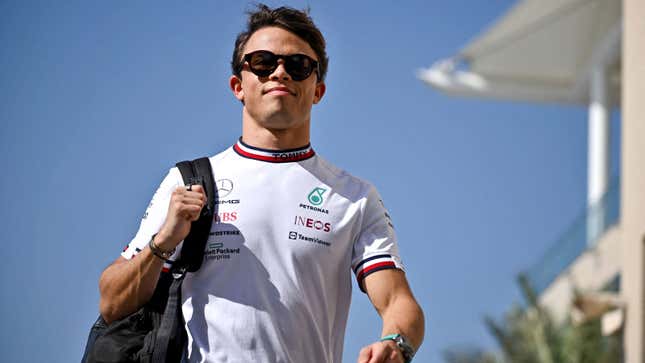 A photo of Nyck de Vries walking through the paddock in Mercedes kit. 