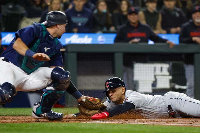 Mar 31, 2023; Seattle, Washington, USA; Cleveland Guardians second baseman Andres Gimenez (0) eludes a tag by Seattle Mariners catcher Cal Raleigh (29) following a second throwing error during the second inning at T-Mobile Park.
