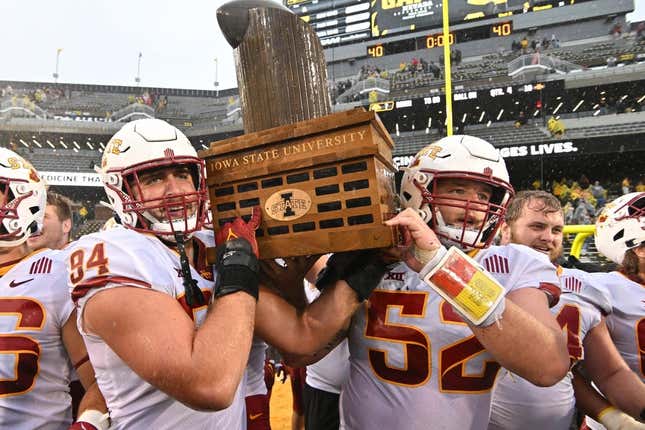 Sep 10, 2022; Iowa City, Iowa, USA; Iowa State Cyclones defensive lineman Kyle Krezek (94) and offensive lineman Trevor Downing (52) carry the Cy-Hawk trophy after the game against the Iowa Hawkeyes at Kinnick Stadium.