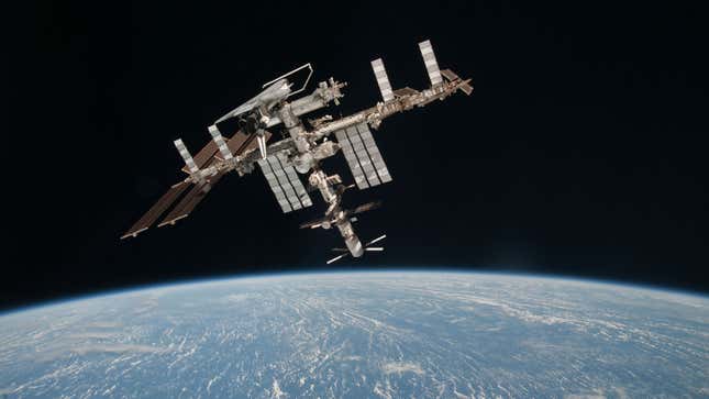 The Space Station orbits earth with a shuttle docked