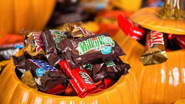 Halloween candy (Milky Way, Twix, Kit Kat, Snickers) in decorative pumpkin