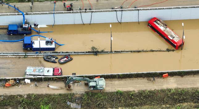 Rescuers work to search for survivors along a road submerged by floodwaters leading to an underground tunnel in Cheongju, South Korea, on July 16, 2023. 