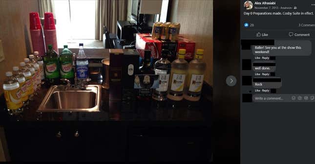 A hotel room kitchen counter stocked with alcohol and drink mixers.