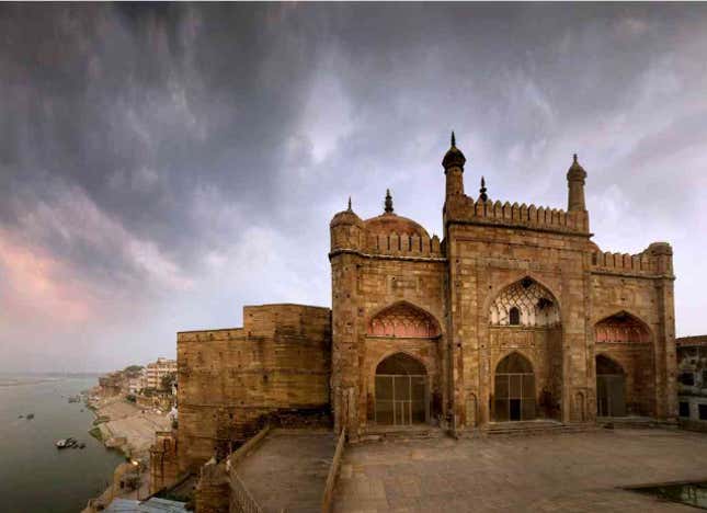Alamgir’s Mosque: The most prominent Mughal monument in the holy city of Banaras is this mosque that emperor Aurangzeb erected in 1669. Built on a terrace high above Panchaganga Ghat, it can be reached by a steep flight of steps from the river below. The vertical proportions of the prayer hall’s triple-bayed facade were once accentuated by a pair of slender corner minarets that rose 50 metres above the terrace, but they do not exist any longer. Battlements conceal three domes of almost equal height, chhatris (elevated dome-shaped pavilions) at the rear corners serve as lookouts. The interior, which comprises a line of only three chambers, is roofed by domes with intricate plaster decoration.