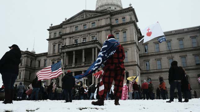  Donald Trump supporters gather around the Michigan State Capitol Building to protest the certification of Joe Biden as the next president of the United States on January 6, 2021 in Lansing, Michigan