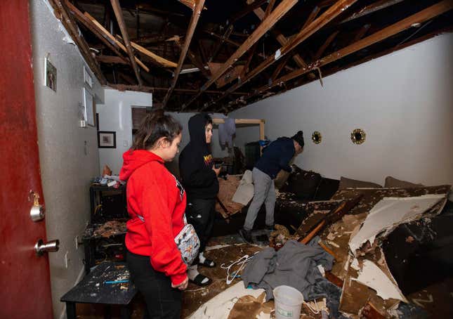 File - Jorge Amezquita, from right, cousin Adalene Castillo and girlfriend Cassandra Duarte look for a TV remote under debris after a tornado ripped the roof off the apartment on Jan. 24, 2023, at Beamer Place Apartments in Houston. When natural or manmade disasters happen, renters insurance can mean the difference between catastrophe and stability. (Yi-Chin Lee/Houston Chronicle via AP, File)
